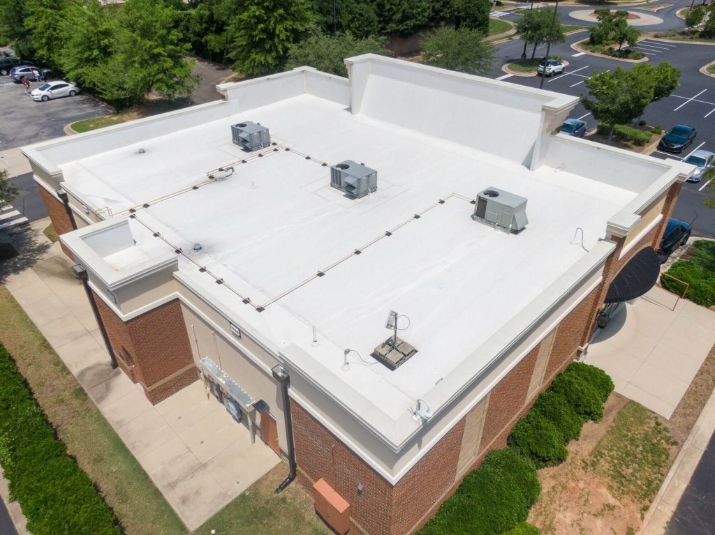 Aerial view of a large commercial flat roof with new roof installed.