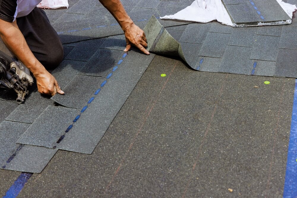 Roofing contractor repairing asphalt shingles on a Pagosa Springs home